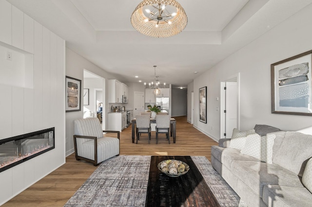 living room featuring a fireplace, hardwood / wood-style floors, and a notable chandelier