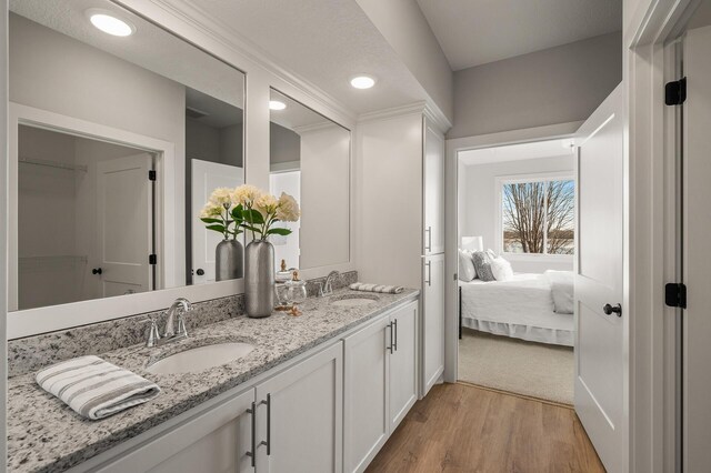 bathroom with wood-type flooring, vanity, and a textured ceiling