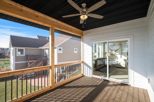 wooden terrace with a lawn and ceiling fan