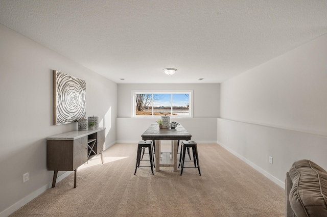 carpeted dining space with a textured ceiling