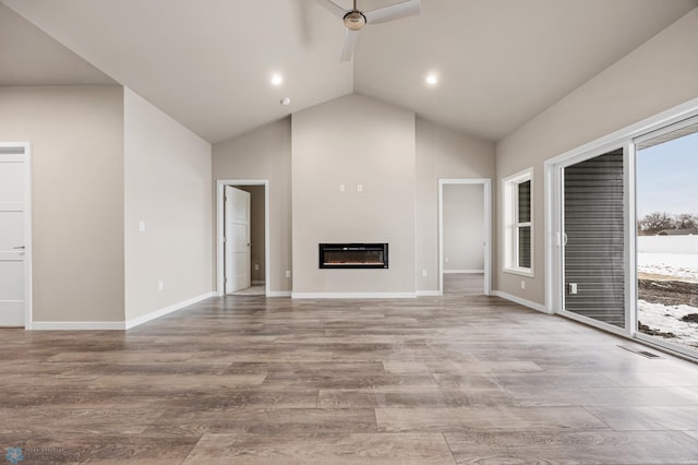 unfurnished living room featuring ceiling fan, vaulted ceiling, and light hardwood / wood-style flooring