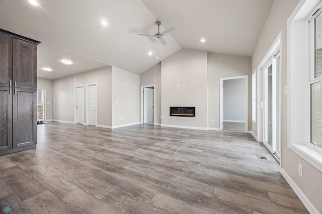 unfurnished living room featuring light hardwood / wood-style flooring, ceiling fan, and lofted ceiling