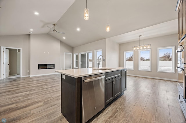 kitchen with dishwasher, sink, an island with sink, lofted ceiling, and light wood-type flooring