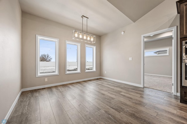 empty room featuring light hardwood / wood-style flooring and an inviting chandelier