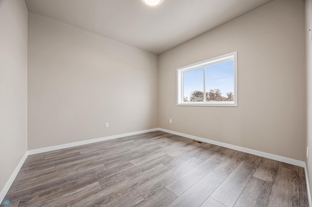 unfurnished room with wood-type flooring