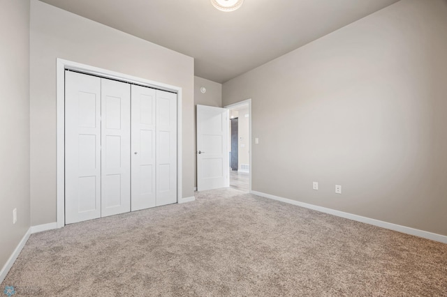 unfurnished bedroom featuring carpet and a closet