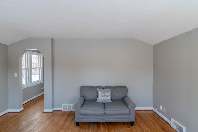 living area with light hardwood / wood-style flooring and vaulted ceiling