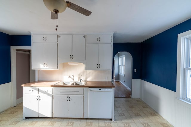 kitchen with backsplash, white dishwasher, ceiling fan, sink, and white cabinets