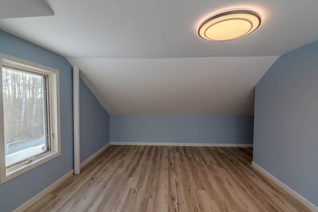 bonus room featuring plenty of natural light, lofted ceiling, and light hardwood / wood-style flooring