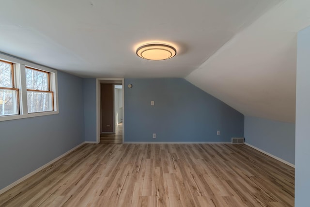 bonus room featuring vaulted ceiling and light hardwood / wood-style flooring