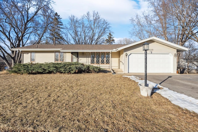 ranch-style home with a garage, covered porch, and a front lawn