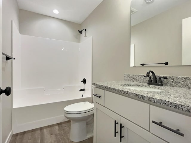 full bathroom featuring shower / bathing tub combination, vanity, hardwood / wood-style flooring, and toilet