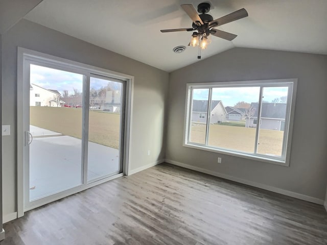 empty room with light hardwood / wood-style floors, vaulted ceiling, and ceiling fan
