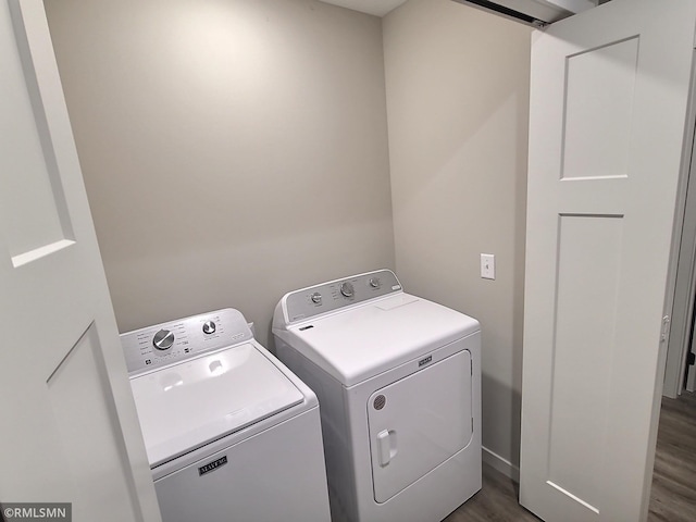 clothes washing area with dark wood-type flooring and washer and dryer