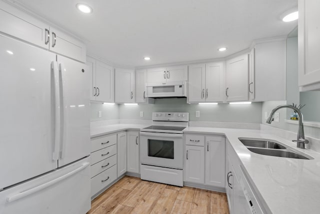 kitchen featuring white cabinets, light wood-type flooring, white appliances, and sink