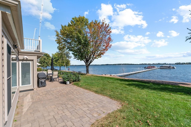 view of patio / terrace featuring a water view, a balcony, and grilling area