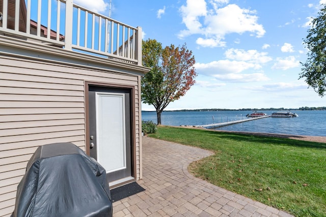 view of patio / terrace featuring grilling area, a balcony, and a water view