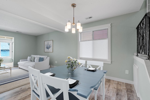 dining room with a chandelier and light wood-type flooring