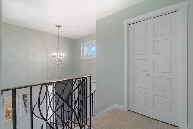 corridor with carpet floors and a notable chandelier