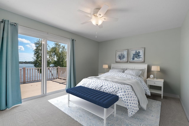 bedroom featuring access to exterior, ceiling fan, a water view, and light carpet