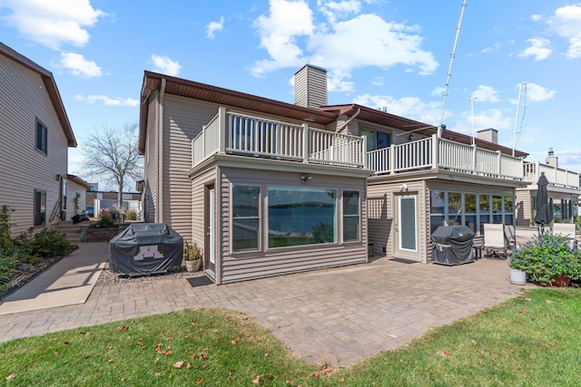 rear view of house with a patio area and a balcony