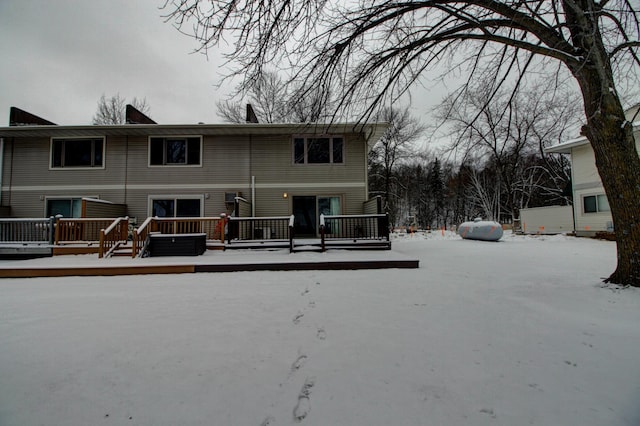 snow covered rear of property featuring a wooden deck