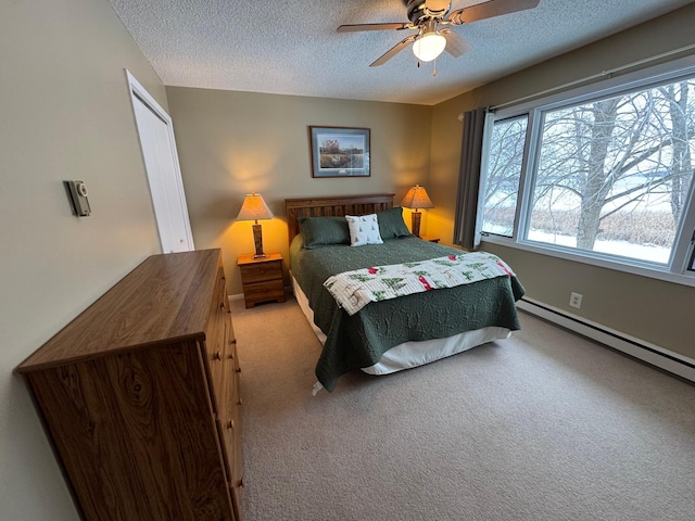 carpeted bedroom with ceiling fan, baseboard heating, and a textured ceiling