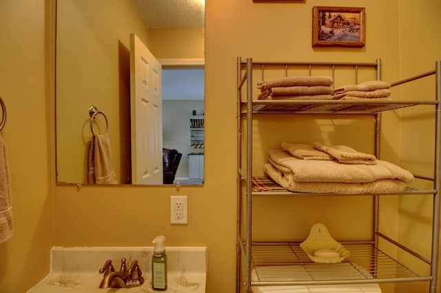 bedroom with a textured ceiling and sink