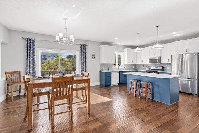 dining space featuring an inviting chandelier, plenty of natural light, and dark hardwood / wood-style flooring