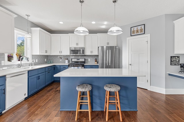 kitchen featuring blue cabinets, a center island, white cabinets, and appliances with stainless steel finishes