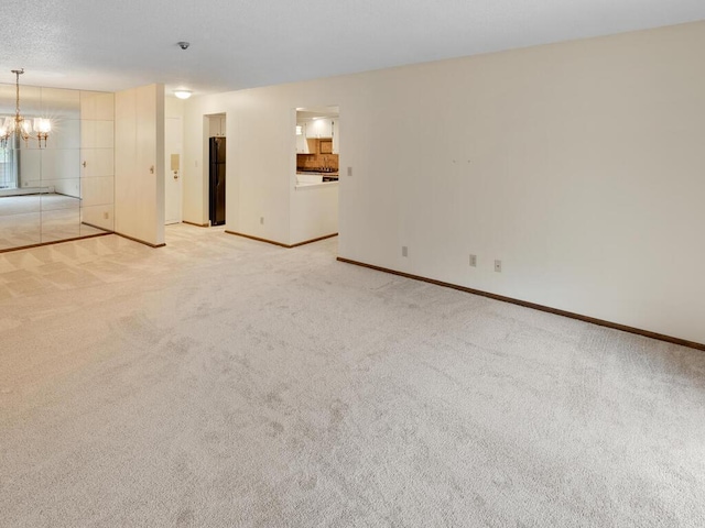 carpeted empty room with an inviting chandelier