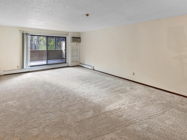 carpeted empty room with an AC wall unit, a textured ceiling, and a baseboard heating unit