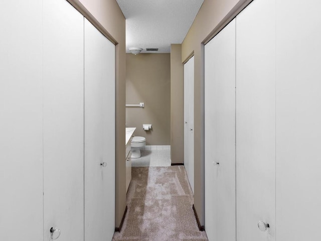 bathroom featuring vanity, toilet, and a textured ceiling