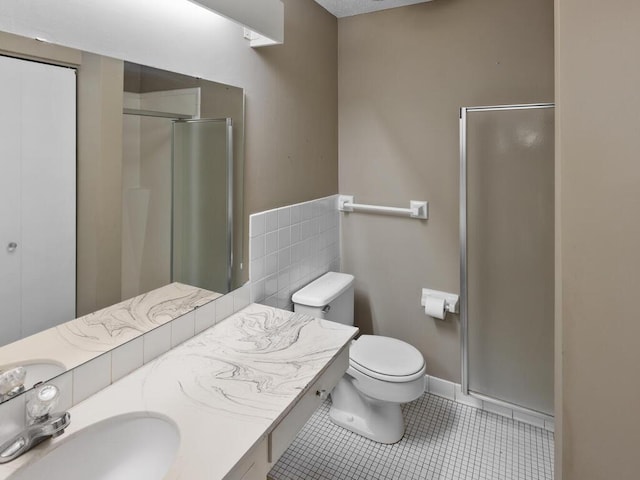 bathroom with toilet, vanity, tile patterned floors, and walk in shower