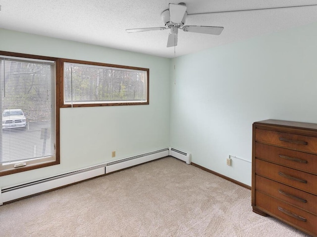 spare room with light carpet, ceiling fan, a textured ceiling, and a baseboard heating unit