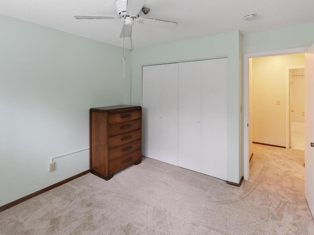 unfurnished bedroom featuring light colored carpet, a closet, and ceiling fan