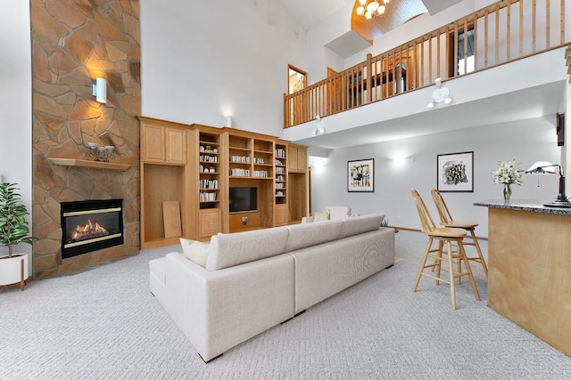 carpeted living room featuring a towering ceiling and a fireplace