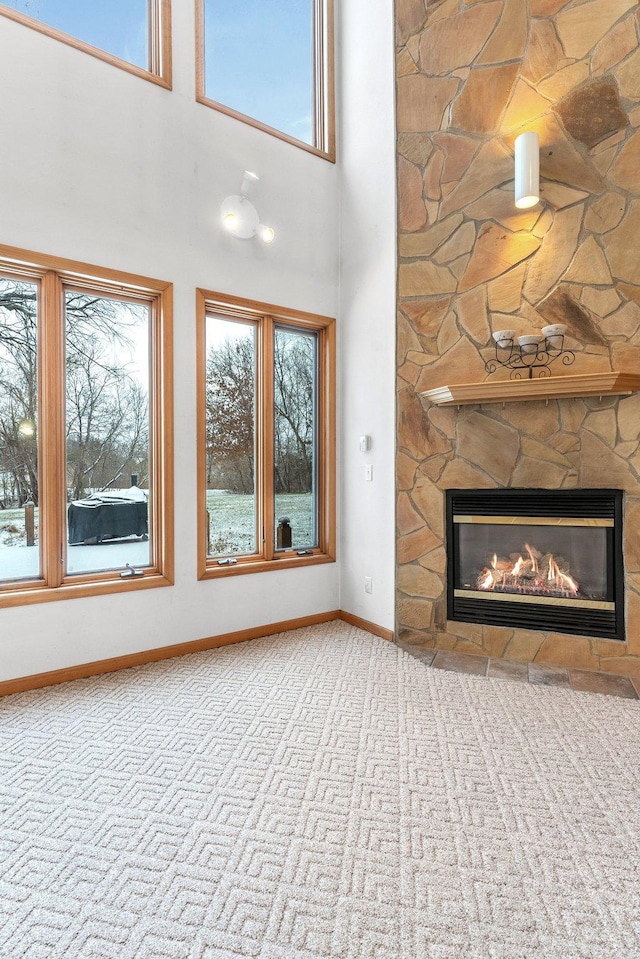 unfurnished living room with a high ceiling and a fireplace