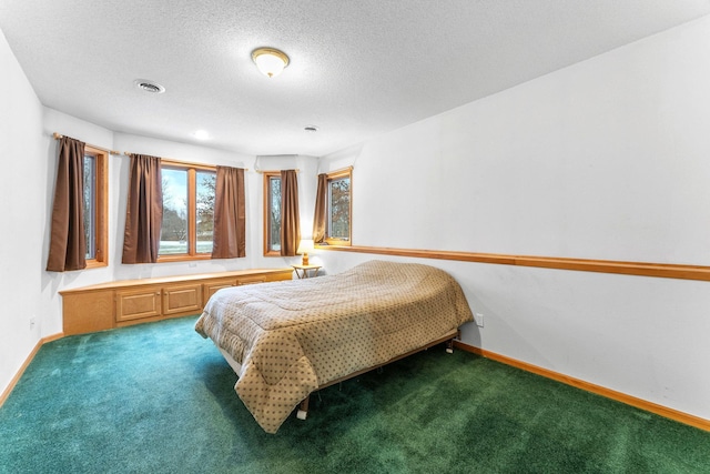 carpeted bedroom with baseboards and a textured ceiling