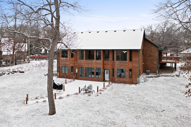 snow covered property with a deck and central air condition unit