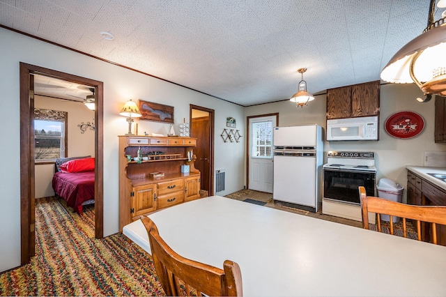 kitchen with radiator, ceiling fan, hanging light fixtures, a textured ceiling, and white appliances