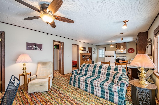 living room featuring ceiling fan, carpet floors, and a textured ceiling