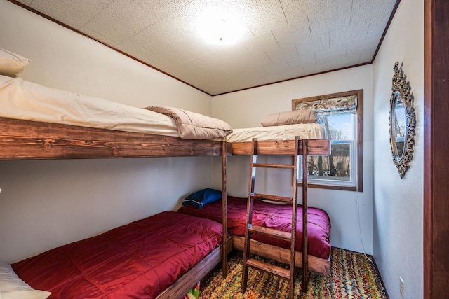 bedroom with lofted ceiling, ornamental molding, and a textured ceiling