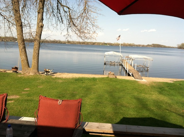 dock area with a yard and a water view