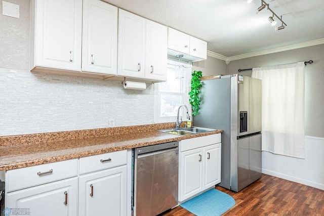 kitchen with appliances with stainless steel finishes, dark hardwood / wood-style flooring, ornamental molding, sink, and white cabinets