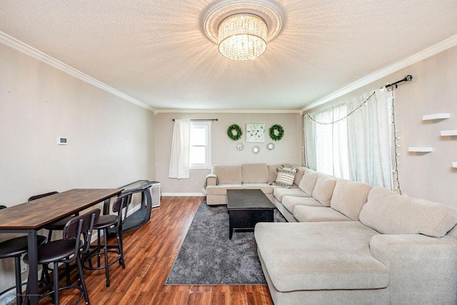 living room featuring dark hardwood / wood-style flooring, ornamental molding, and an inviting chandelier