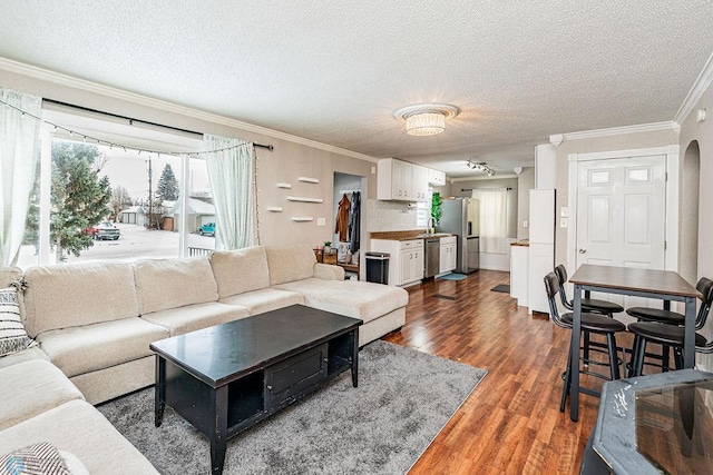 living room featuring a textured ceiling, dark hardwood / wood-style floors, and crown molding