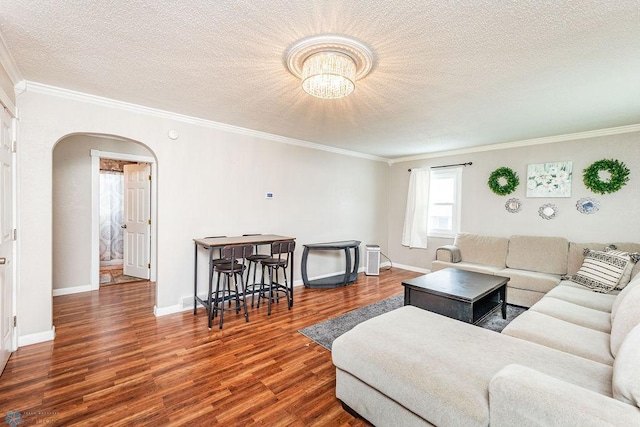 living room featuring dark hardwood / wood-style floors, ornamental molding, and a textured ceiling