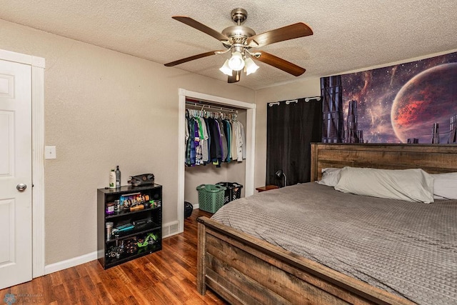 bedroom with ceiling fan, dark hardwood / wood-style flooring, a textured ceiling, and a closet