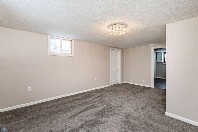 unfurnished room with a textured ceiling and dark carpet